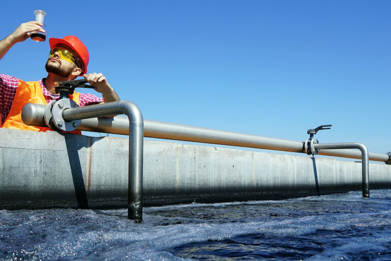 An engineer controlling a quality of water ,aerated activated sludge tank at a waste water treatment plant. pollution